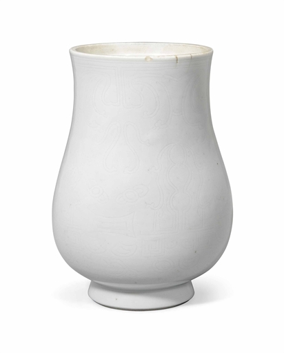 A CHINESE WHITE-GLAZED VASE, HU
KANGXI PERIOD (1662-1722)
Supported on a slightly spreading foot,