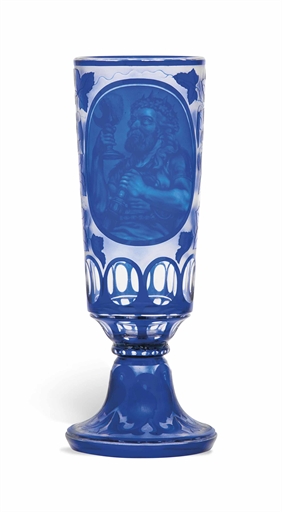 A BOHEMIAN BLUE OVERLAY CUT AND ENGRAVED GLASS VASE
CIRCA 1860
Of slender tapering form with