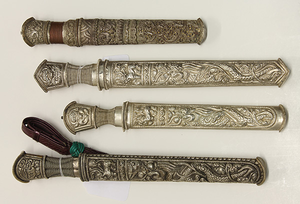(lot of 4) Southeast Asian knife group, each having a repousse decorated grip and sheath, largest