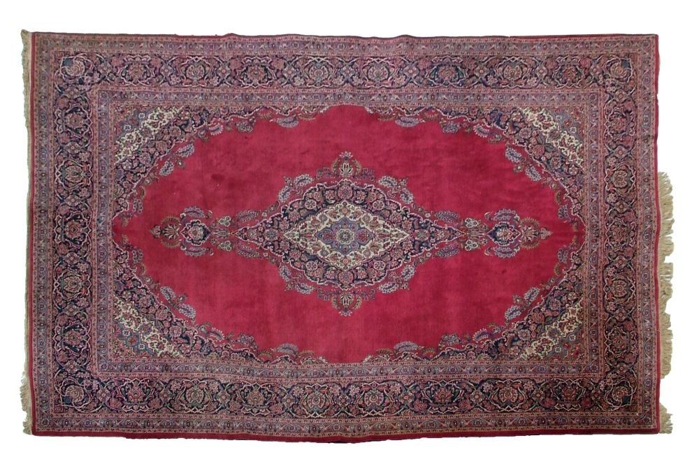 Kashan carpet decorated with a central medallion on a red ground within a loose floral and multi