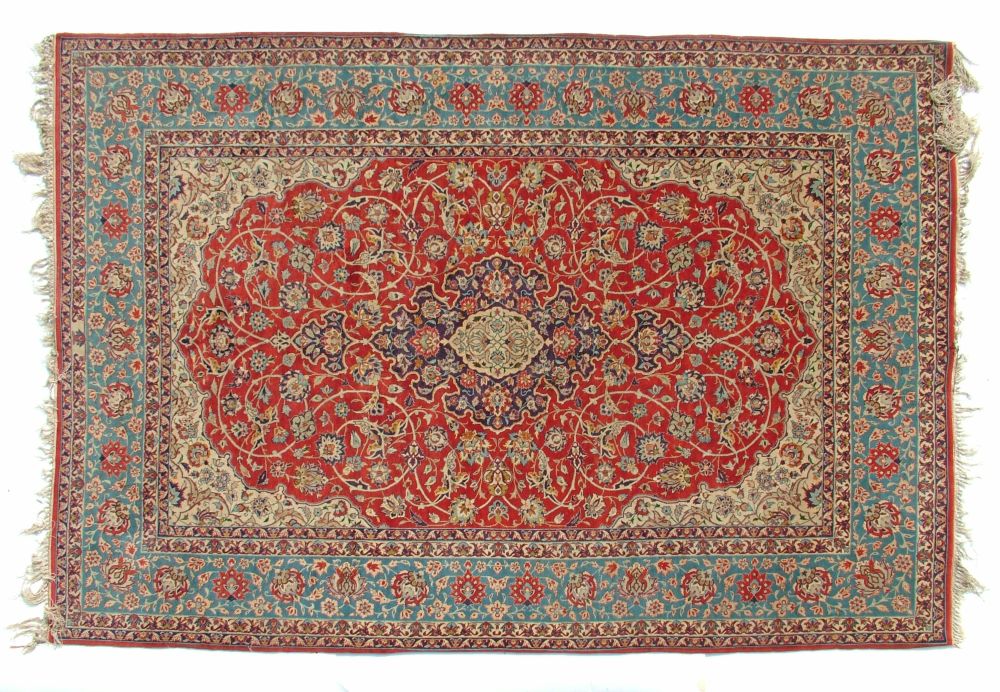 Isfahan rug decorated with a central medallion amongst foliage on an orange ground within multi