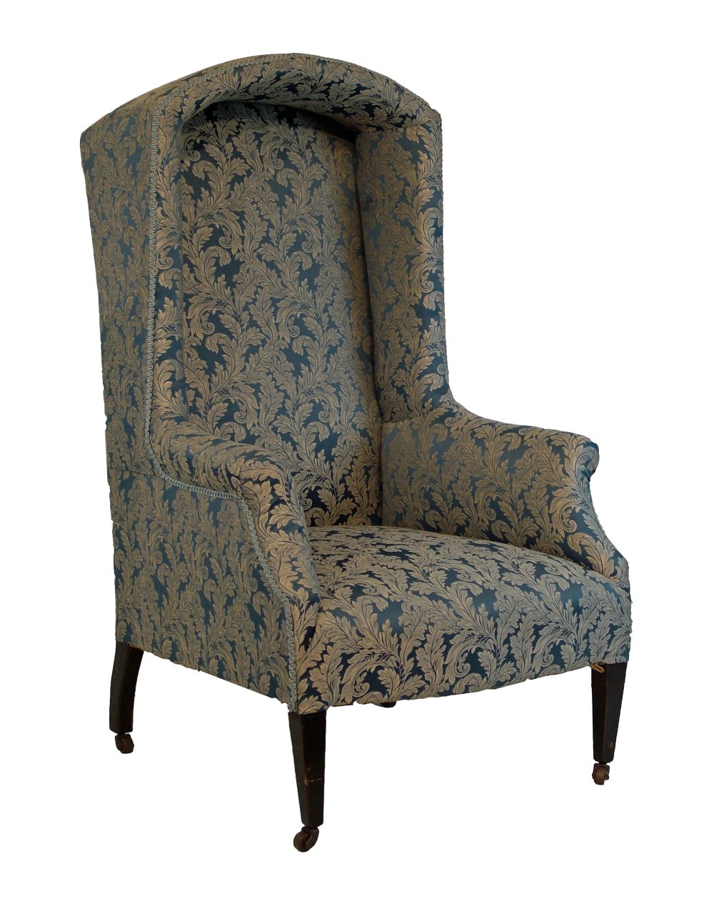 Early 20th Century arch top wing back porter`s chair upholstered in blue and off-white brocade and s