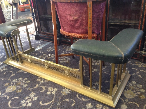 A Maple & Co. brass club fender with original green leatherette covered seats.