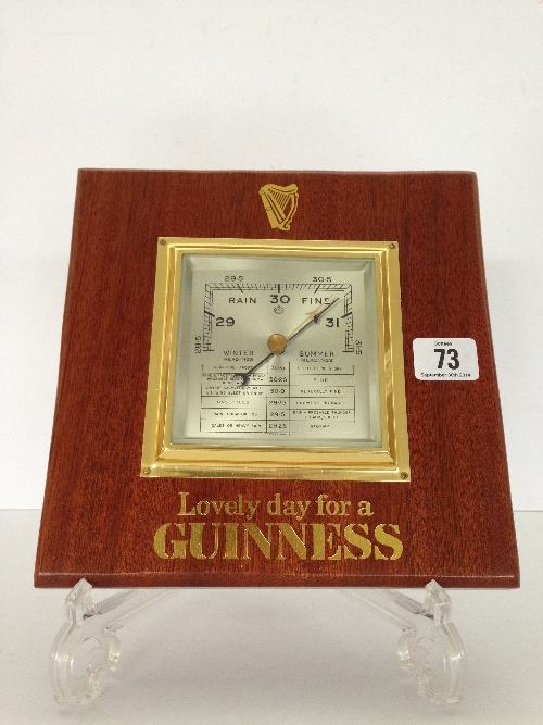 An oak framed Guinness advertising barometer inscribed 'Lovely day for a Guinness' in gold