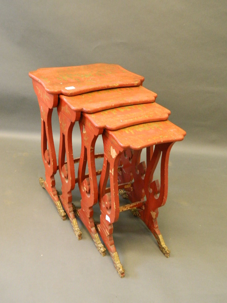 A nest of four early C20th Chinese red lacquered occaisional tables of shaped form, decorated with