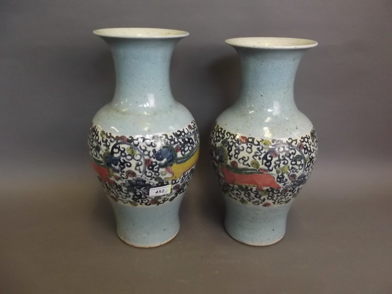 A pair of early C20th Chinese crackleware pottery vases painted with kylins on a pale blue ground,