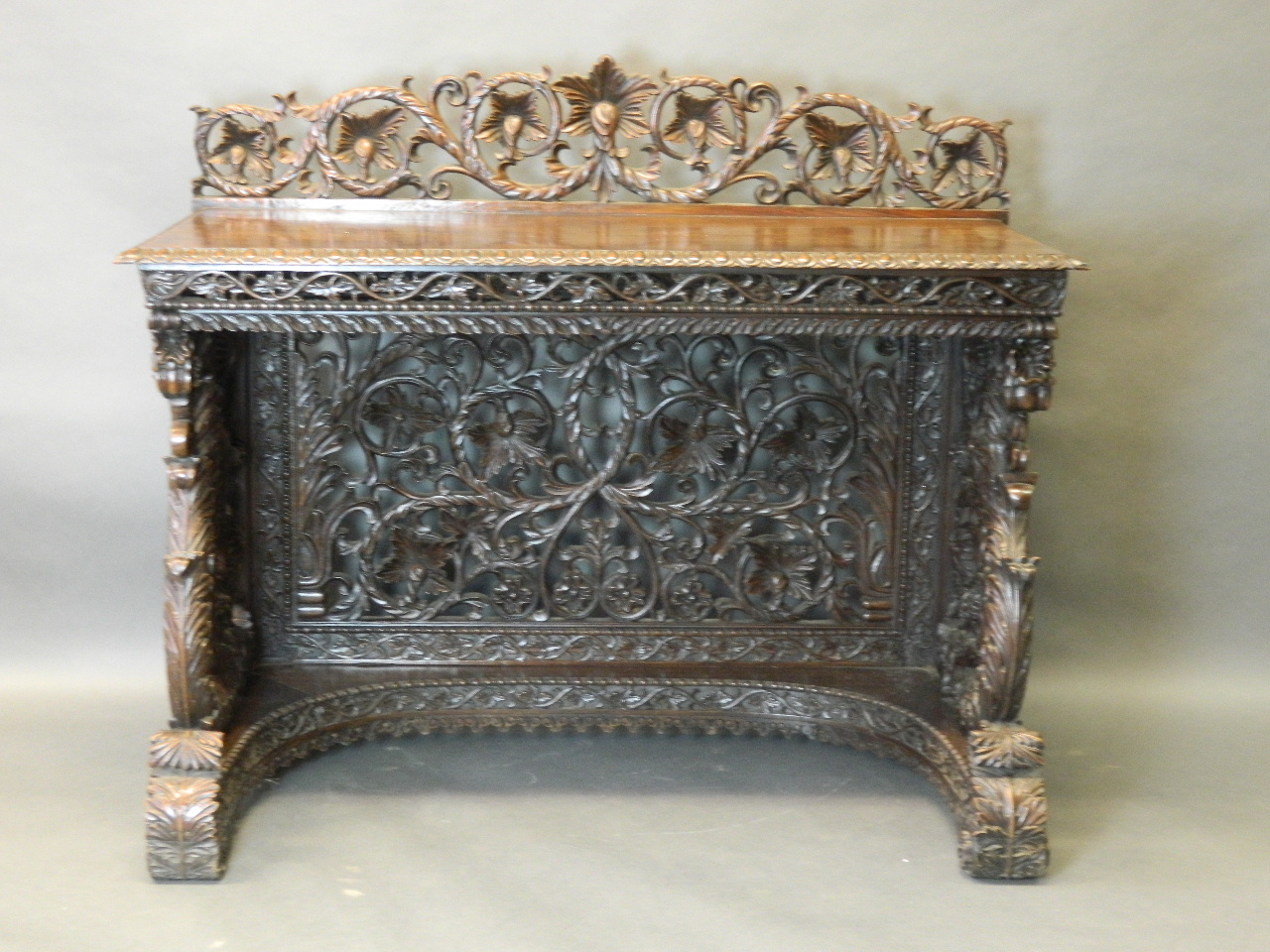 A fine early C19th Anglo-Indian carved teak console table with a pierced and carved back and