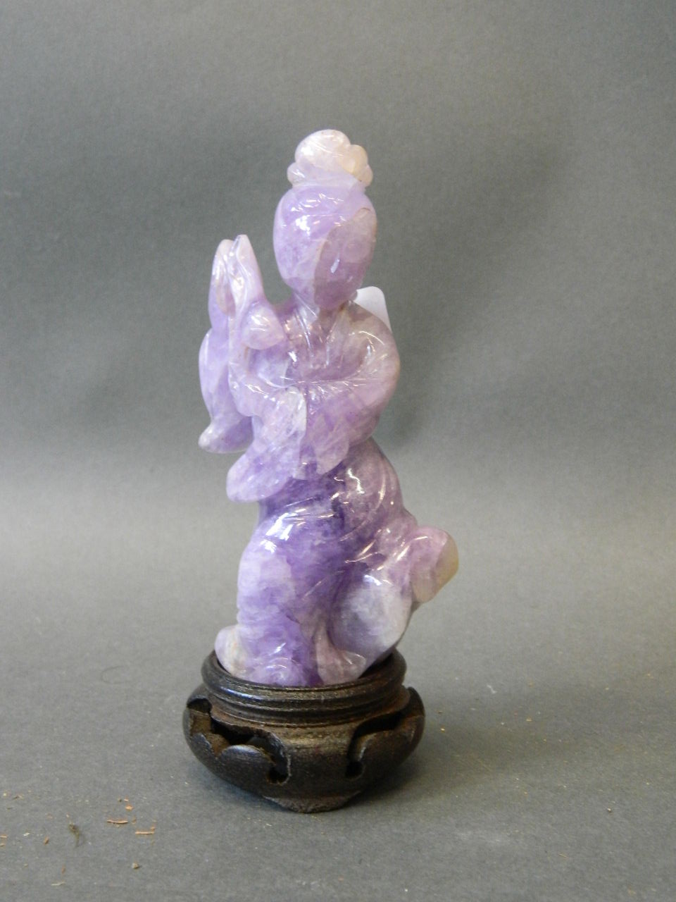 A fine early C20th mauve quartz figure of Guan Yin holding a lotus, on a later wood stand, figure