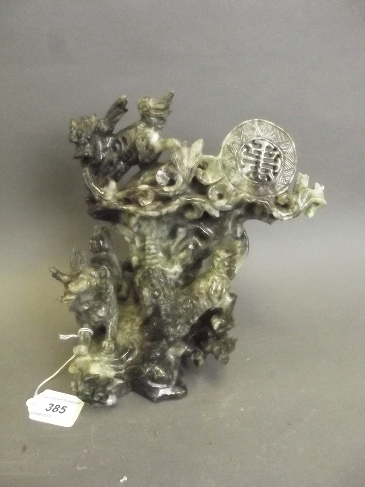 A large Chinese jadeite carving of three kylin on a rocky outcrop 9" high, 8" wide