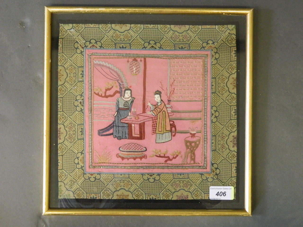 A mid C20th Chinese embroidered silk depicting two women in an interior lighting incense, framed,