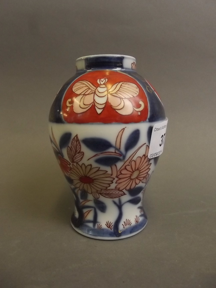 A small C18th Japanese Arita pottery vase painted with stylised flowers and butterflies etc. 4½