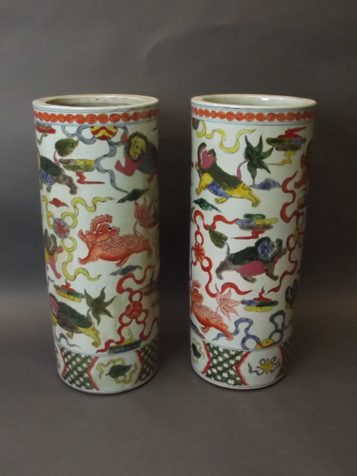 A pair of Chinese pottery stick stands with painted enamel decoration of kylins, six character
