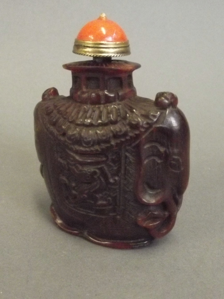 A Chinese horn snuff bottle carved in the form of a saddled elephant, 3'' high