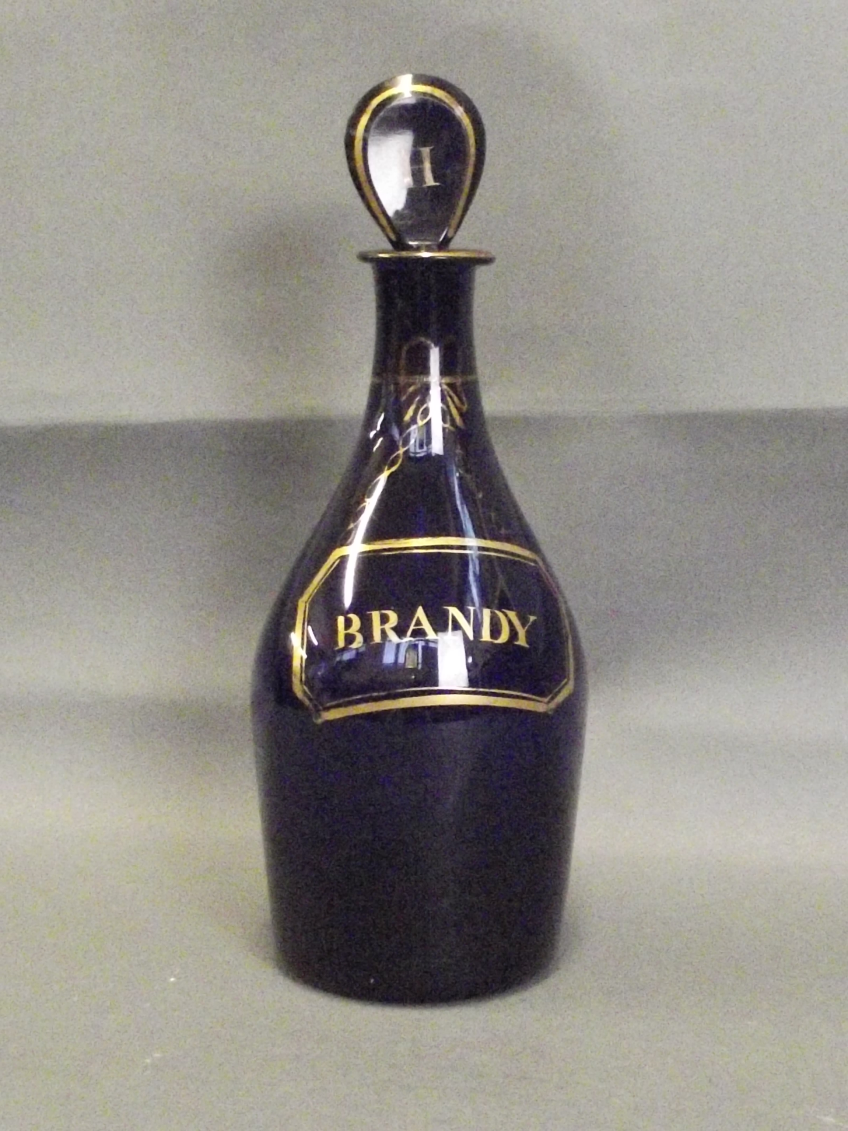 A Bristol blue glass decanter with gold decoration, inscribed Brandy, 9'' high