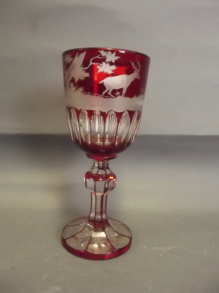 A C19th Bohemian ruby glass goblet engraved with stags etc, 8½'' high