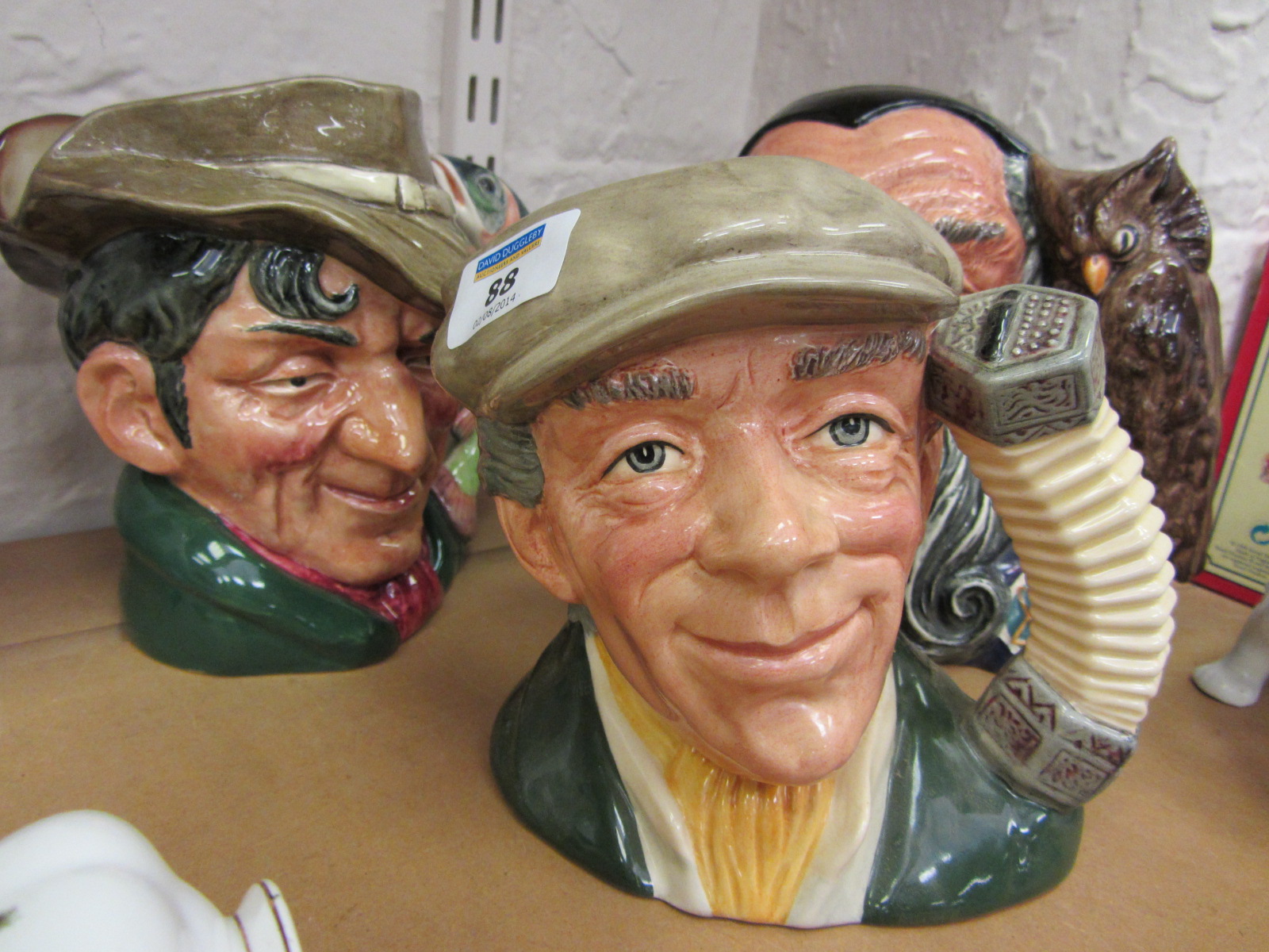 Three large Royal Doulton character jugs The Busker, The Poacher and Merlin