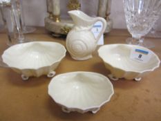 A trio of Belleek scallop shell dishes with brown backstamps and a similar shell moulded jug with