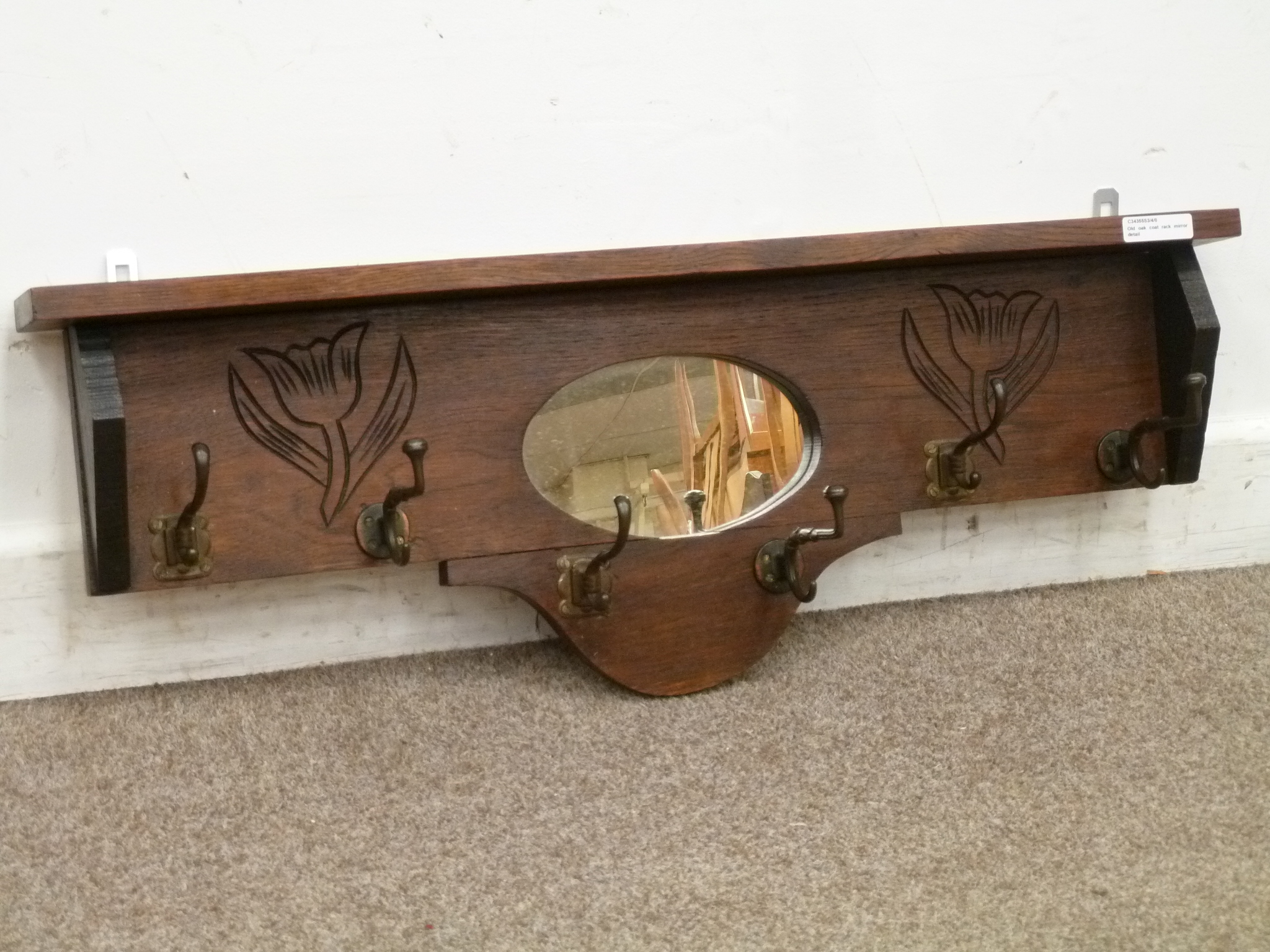 Early 20th century wall mounted coat rack, with carved flower details and mirror back, fitted with