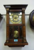 A mahogany wall clock, with Arts and Crafts style dial