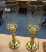 Pair of brass candlesticks with clear glass shades
