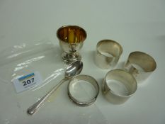 Four silver napkin rings, egg cup and spoon (approx 4.5oz)