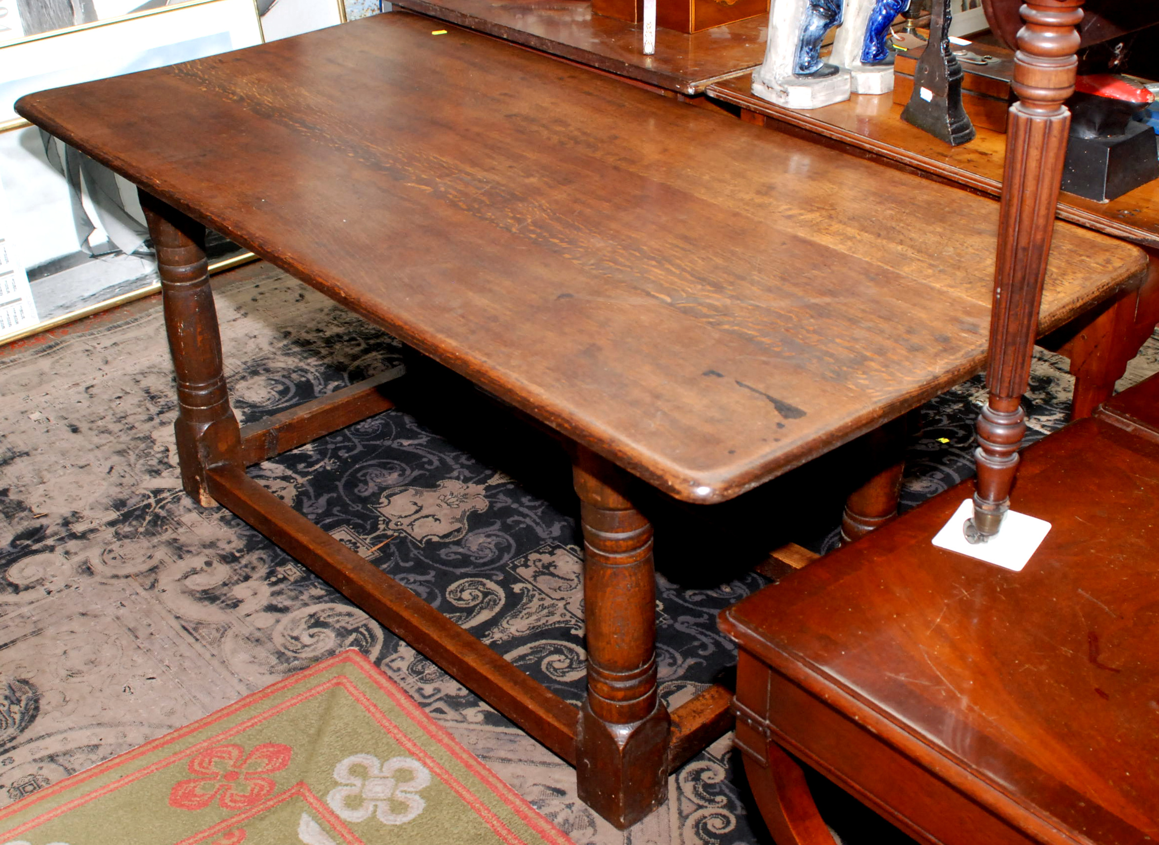 An oak joined dining table in 17th century style with plank top, turned legs and low stretchers,