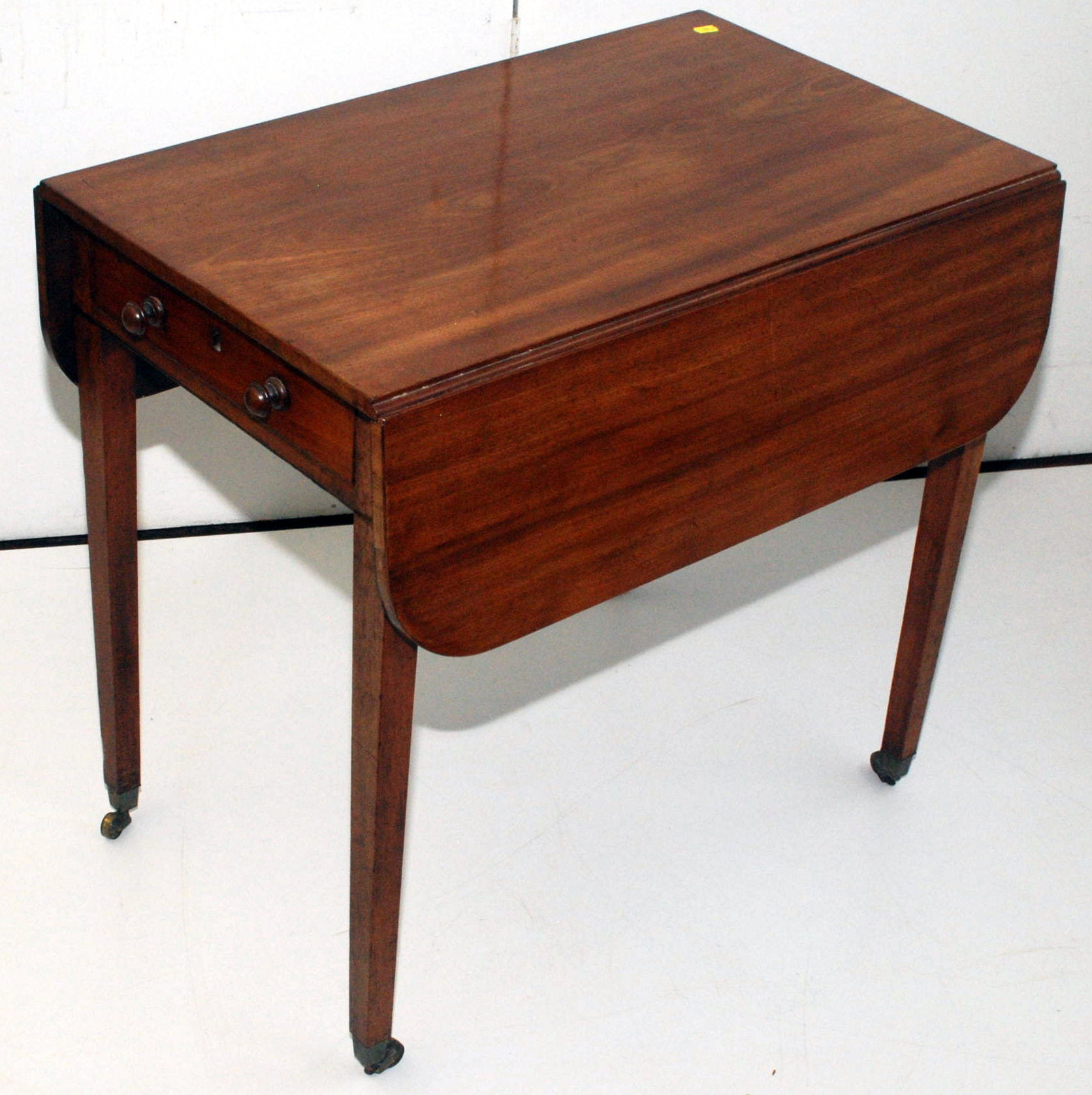 A George III mahogany Pembroke table with tapering square section legs.