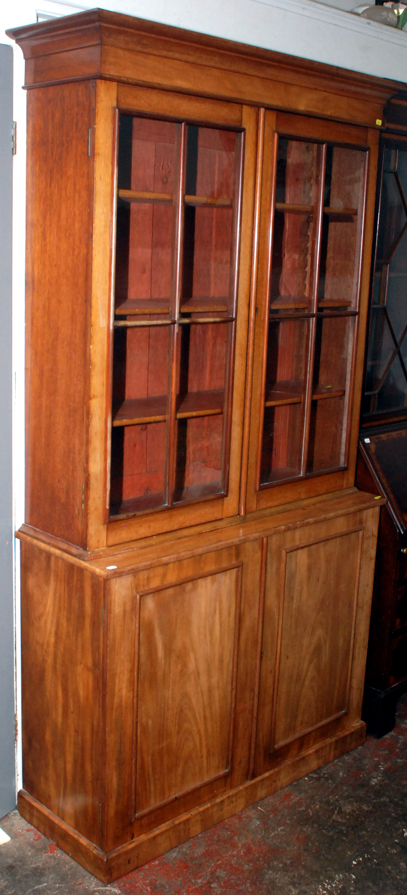 A Victorian mahogany bookcase, the upper section with glazed doors, the base with panelled doors,