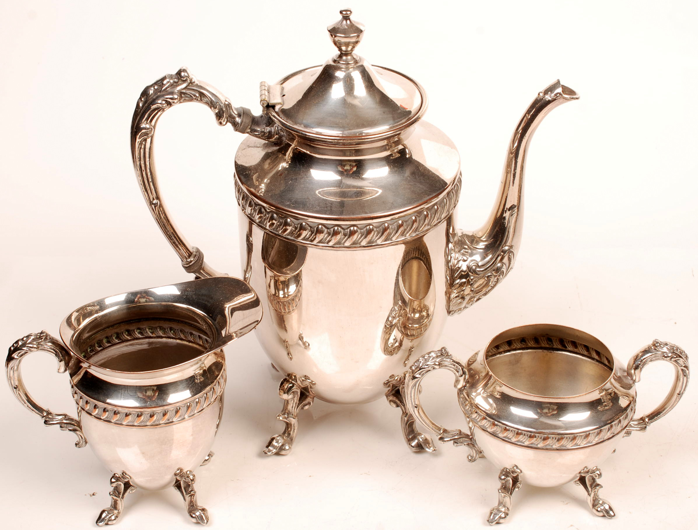 A three piece tea service, each piece with foliate cast handles.