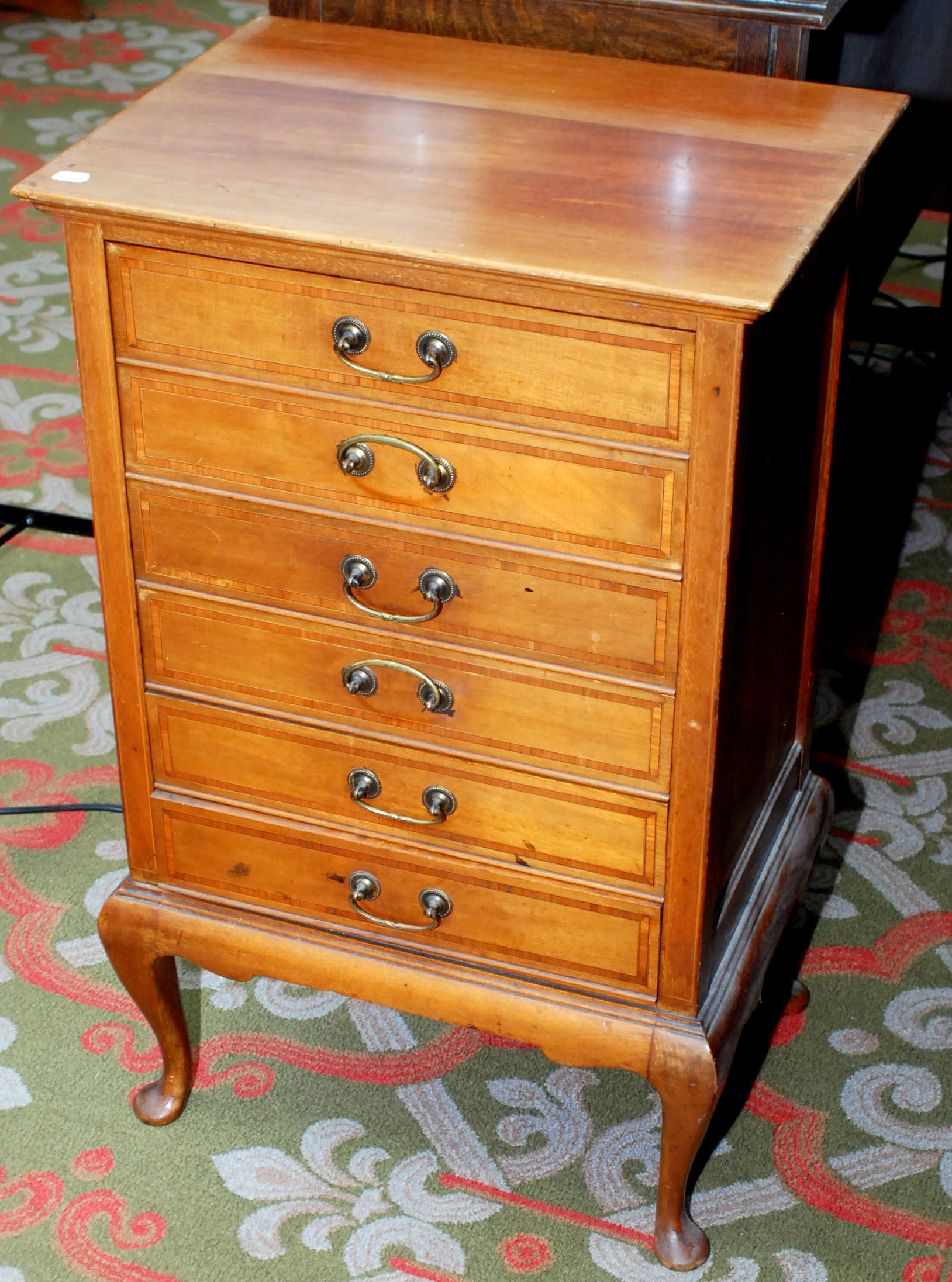 An Edwardian satinwood cross banded mahogany music chest of six fall front drawers on cabriole legs.