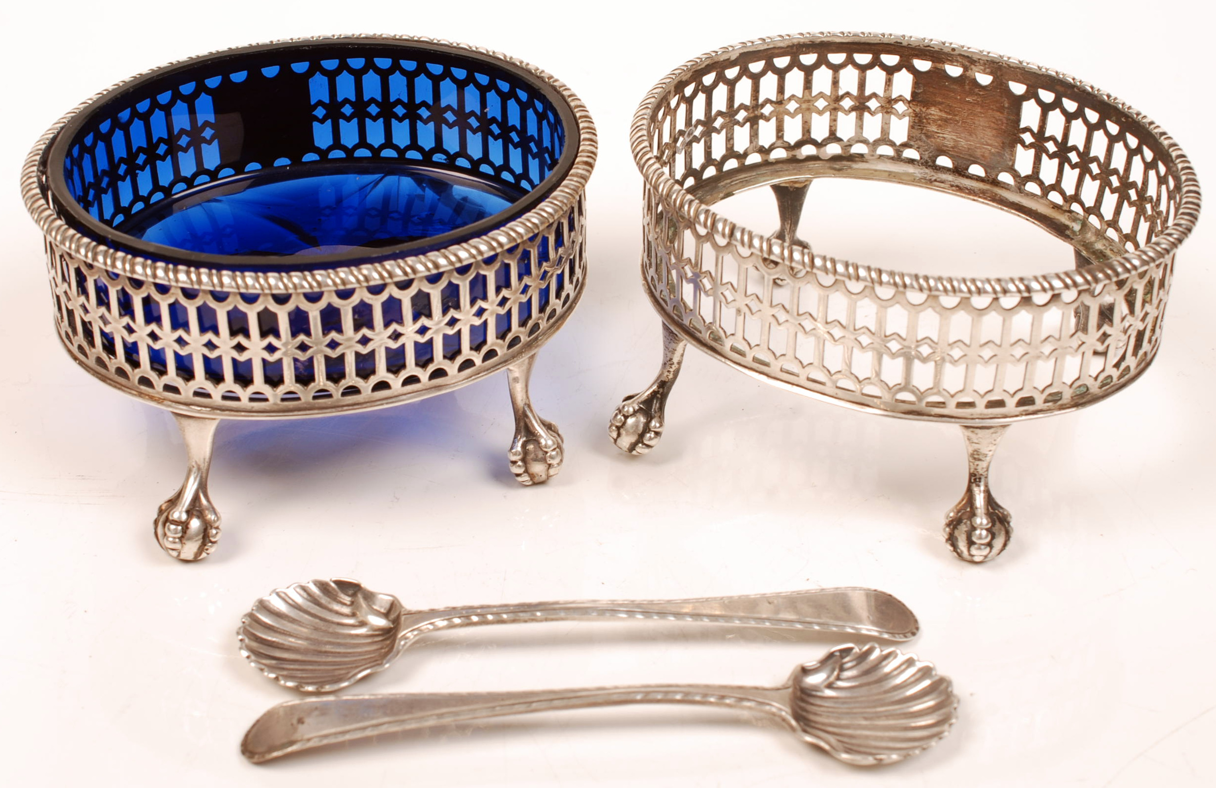 A pair of Georgian silver oval salts with pierced sides and rope-twist border, each resting on