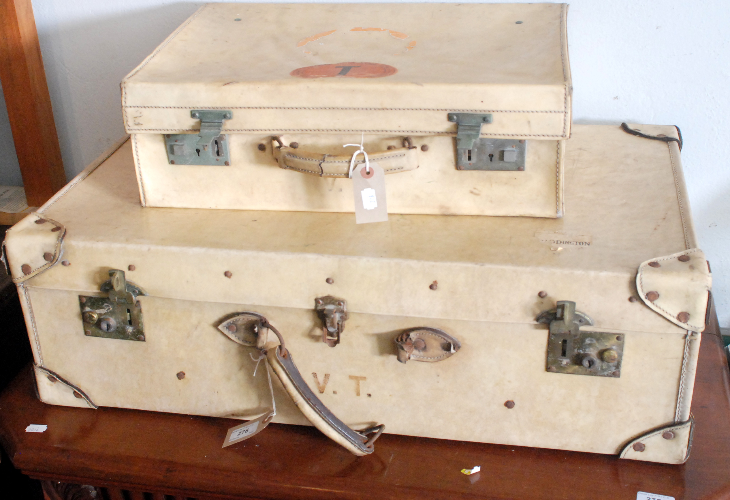 A large pigskin suitcase and a similar smaller case.