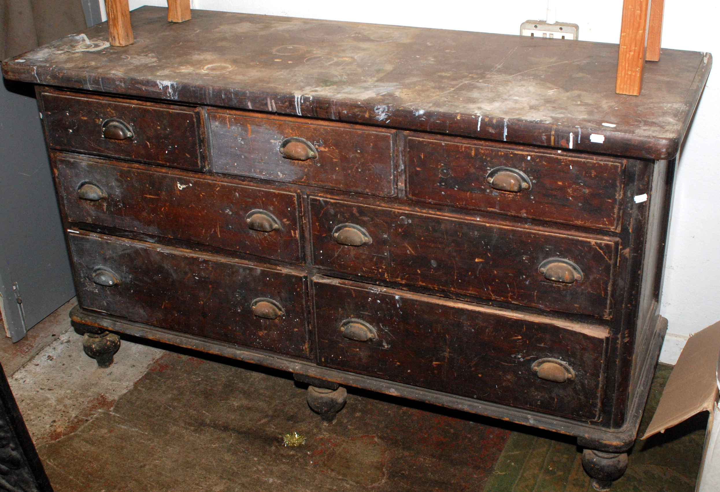 A pine low dresser fitted an arrangement of seven drawers on turned legs, width 152cm.