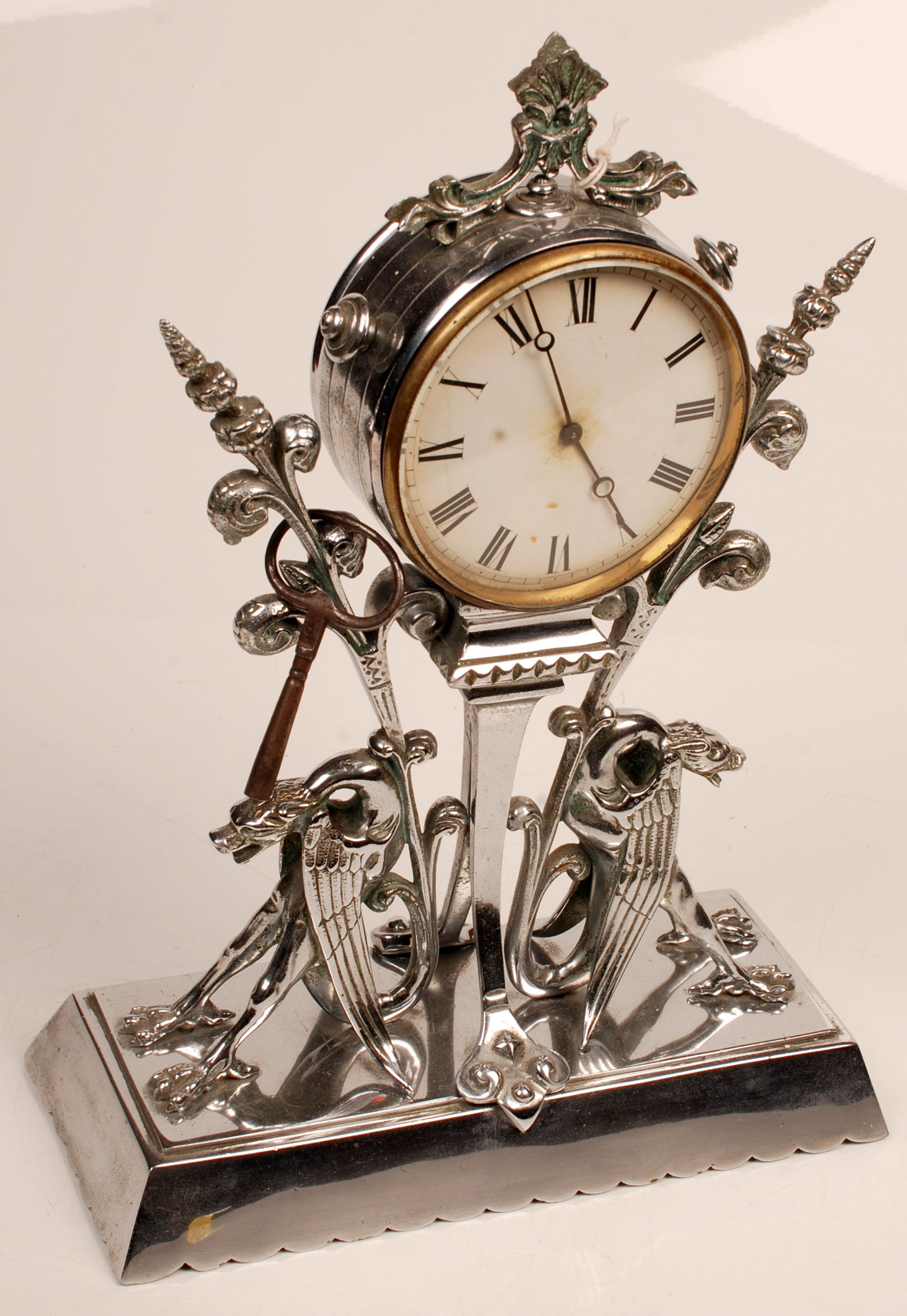 A timepiece, the chromium plated case inspired by Christopher Dresser with supporting gryphon-like