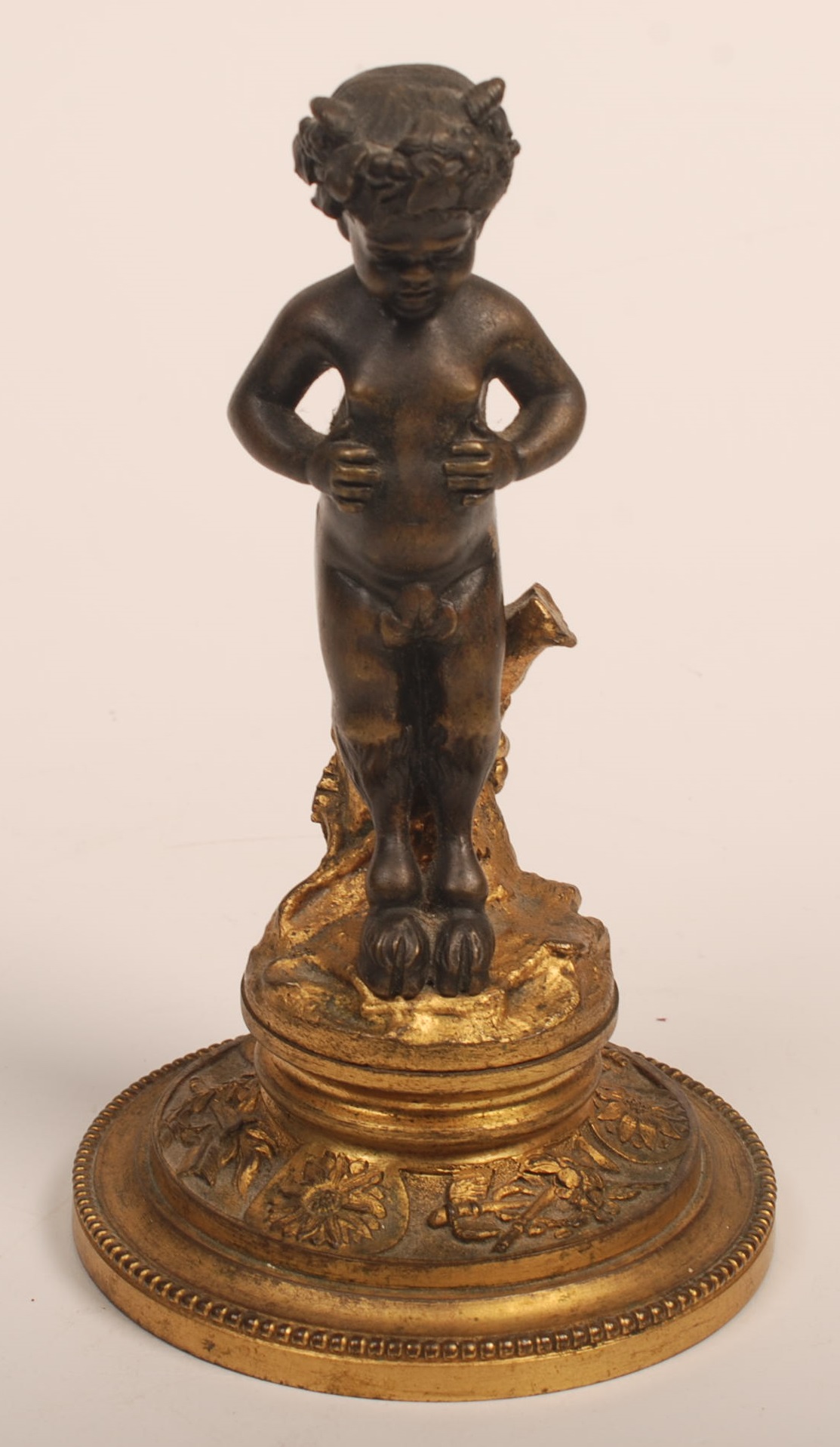 A 19th century bronze and gilt bronze figure of a young satyr. Height 17cm.