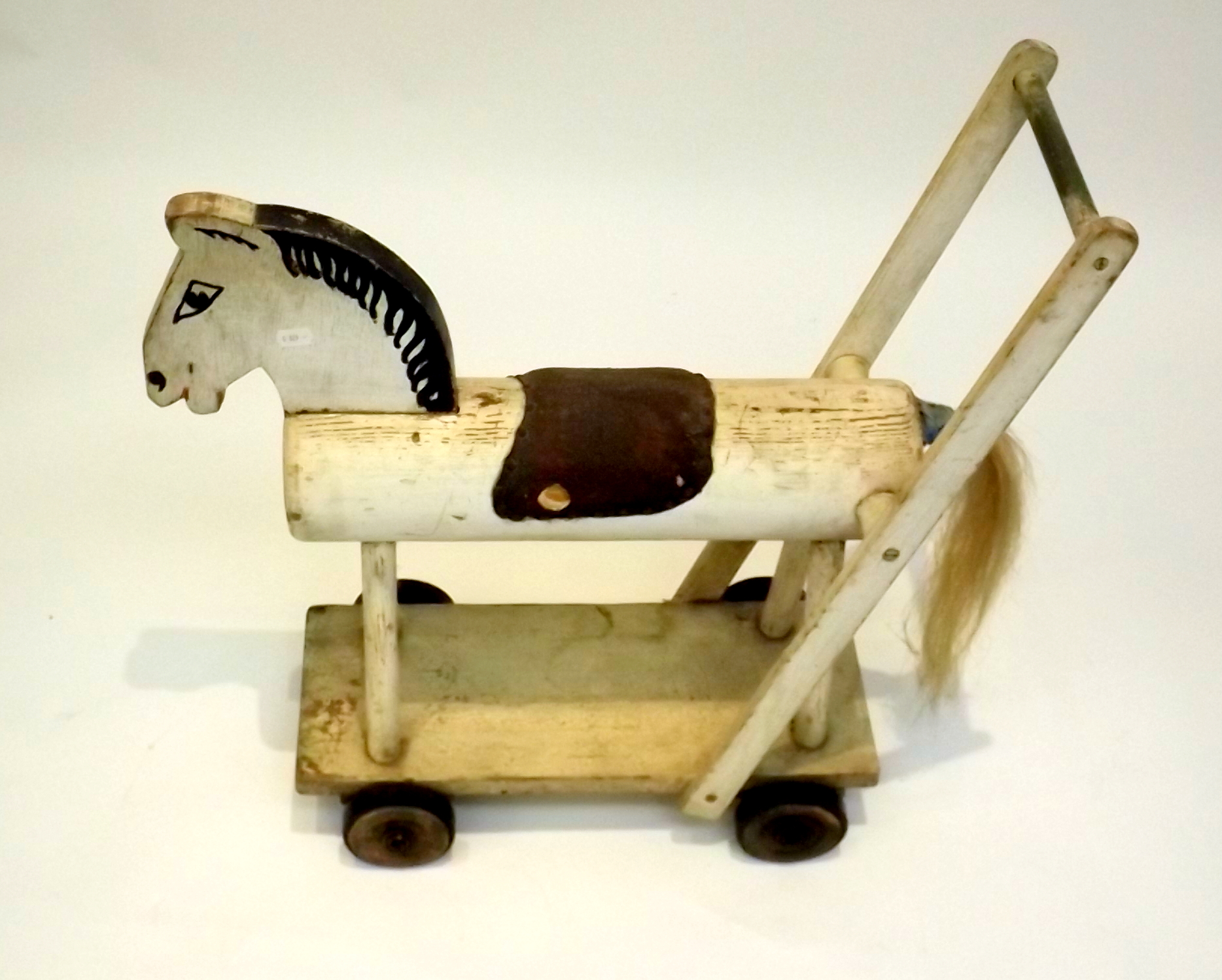 A 1950's homemade push along toy horse.