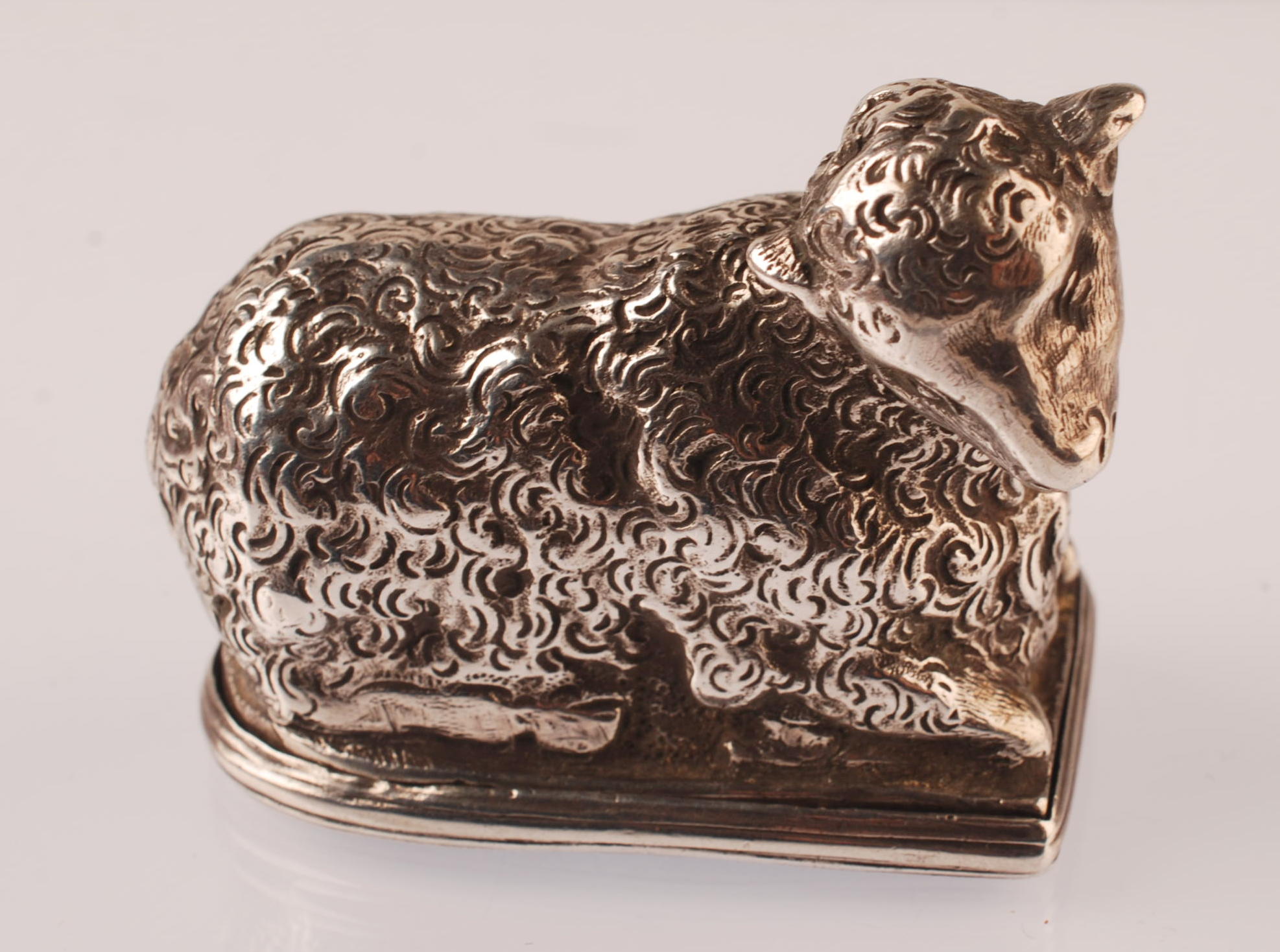 A silver coloured metal snuffbox in the form of a sheep.