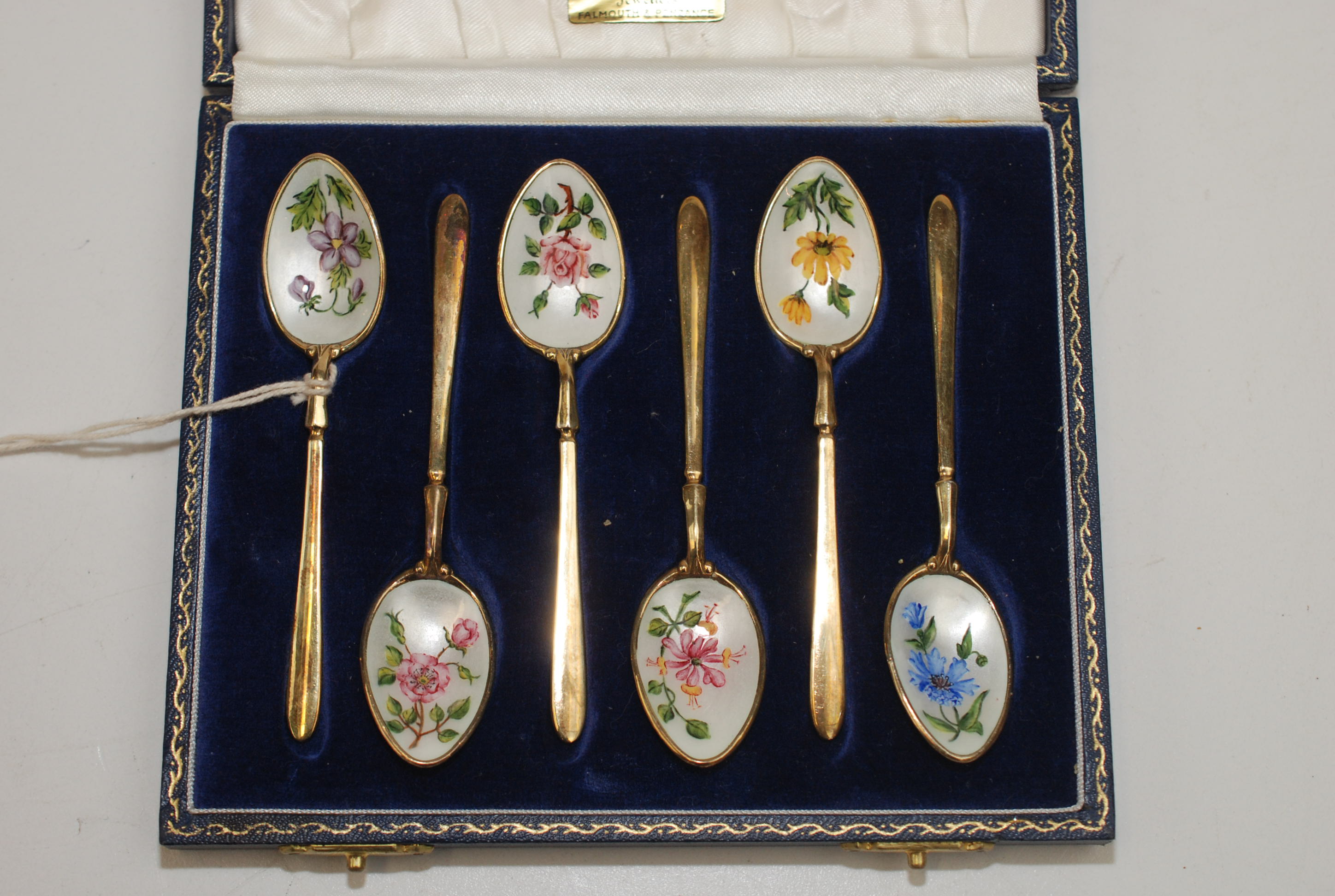 A set of six modern silver gilt teaspoons, the bowl of each hand enamelled with a different flower