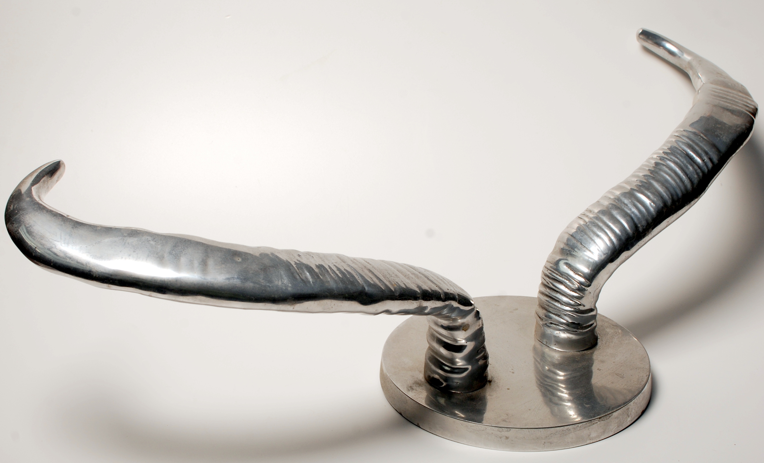 A post-war aluminium Pol's Potten coat rack in the form of a pair of cow horns on a circular back