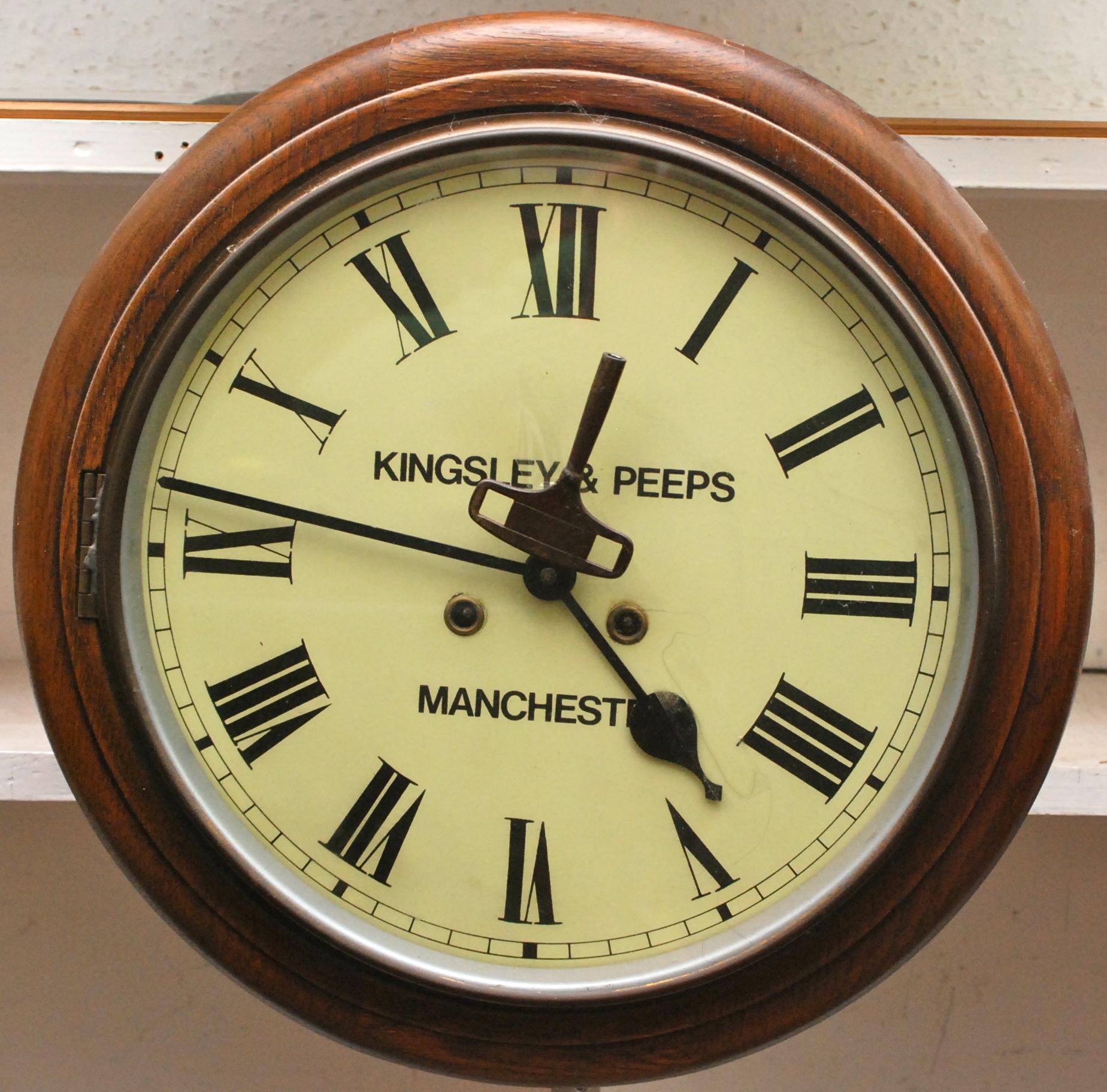 A wall clock signed Kingsley & Peeps, Manchester in oak case.