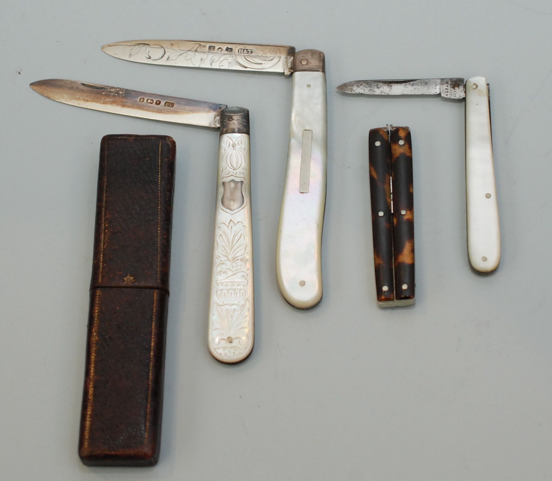 Ttwo silver bladed fruit knives, one other pocket knife and a pair of folding scissors.