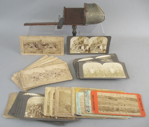 A late 19th Century hand held stereoscopic viewer, dated 1897 and approximately forty seven cards