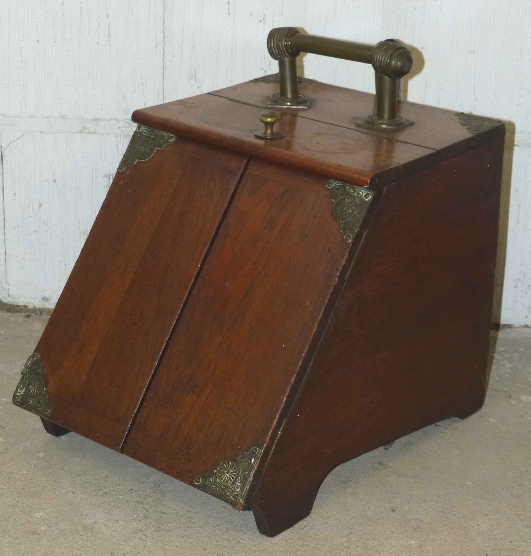 An Edwardian walnut coal box, with brass mounts and handles, the sloping front with two patent