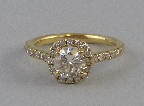 A diamond cluster ring, comprising a central brilliant cut diamond (0.76ct) claw set over a halo of