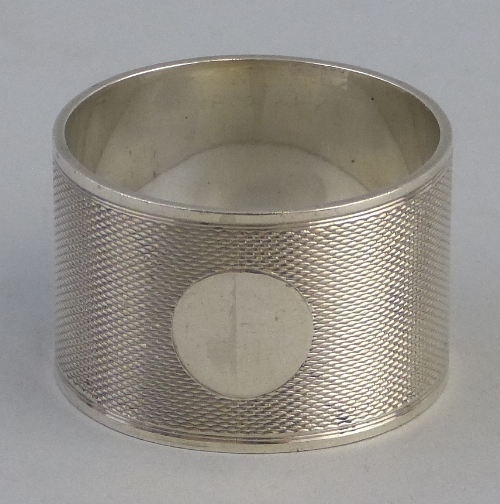A napkin ring, of cylindrical form with circular blank cartouche on an engine turned ground, 3cm