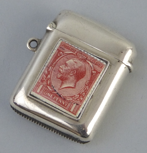 An Edwardian vesta case, of rounded oblong form with hinged lid, the front enamelled with a penny