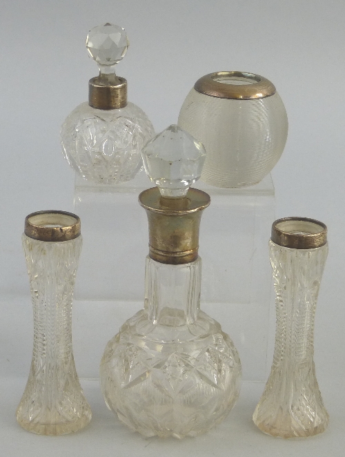 A cut glass scent bottle, of spherical form with elongated neck and flared silver collar, 15.5cm