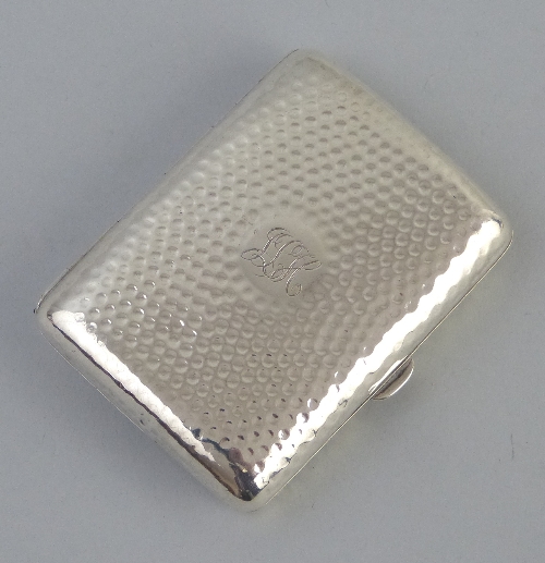 An Edwardian cigarette case, of hinged rounded oblong form with central monogram on a hammered