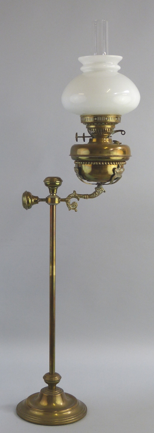 A desk top brass oil lamp, with stepped circular base and central tubular column with rise and fall