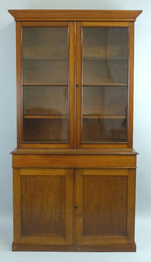 A late 19th/early 20th Century mahogany bookcase cabinet, having flared pediment over two glazed